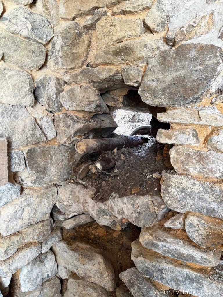 repointing a stone wall with old pipes embedded in the wall Stone Carriage House Gym: Part 4