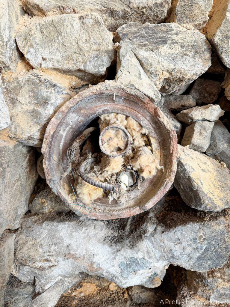 repointing a stone wall with old pipes embedded in the wall Stone Carriage House Gym: Part 4