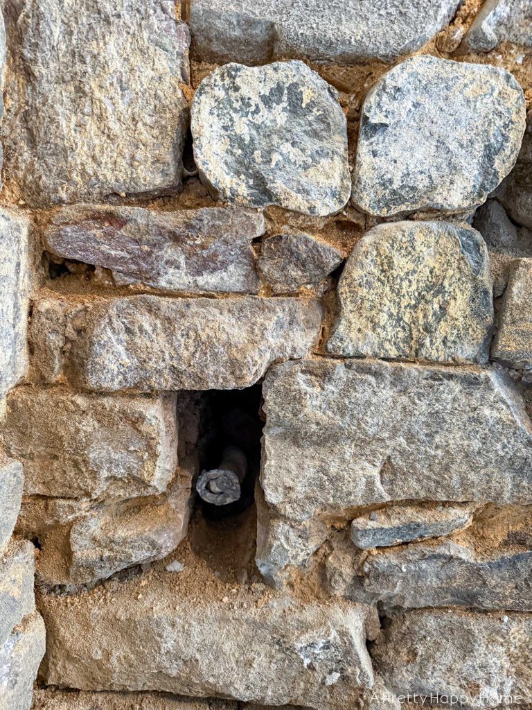 repointing a stone wall with old pipes embedded in the wall Stone Carriage House Gym: Part 4
