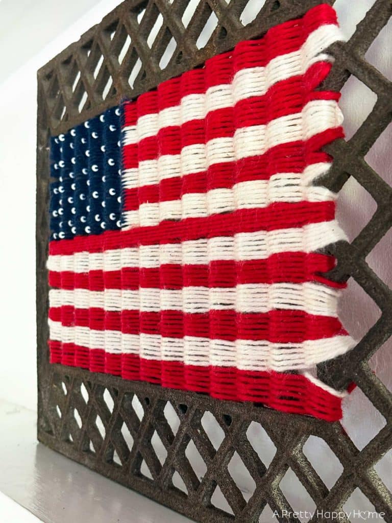 Woven American Flag on an Antique Grate in a colonial era farmhouse flag is woven with red white and blue yarn
