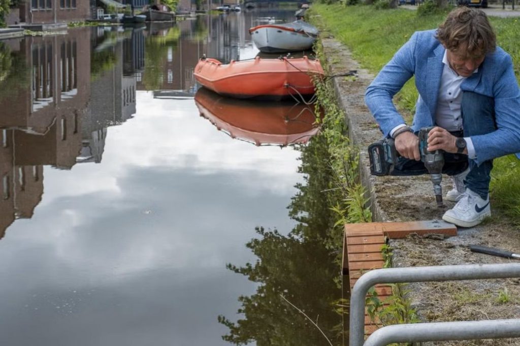 man installing cat staircase on canal in amersfoort netherlands via good news network on the happy list
