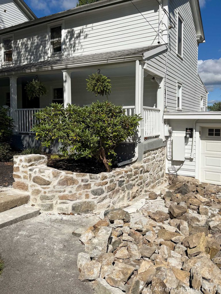 Curved Fieldstone Wall: Part 5, Porch Wall removing concrete skim coat on a stone foundation wall and repointing with lime mortar connecting a stone foundation to a fieldstone wall