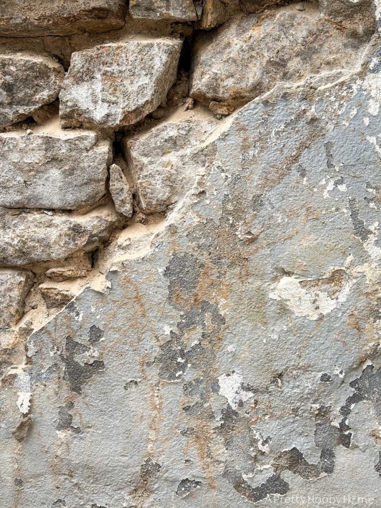 Curved Fieldstone Wall: Part 5, Porch Wall removing concrete skim coat on a stone foundation wall and repointing with lime mortar
