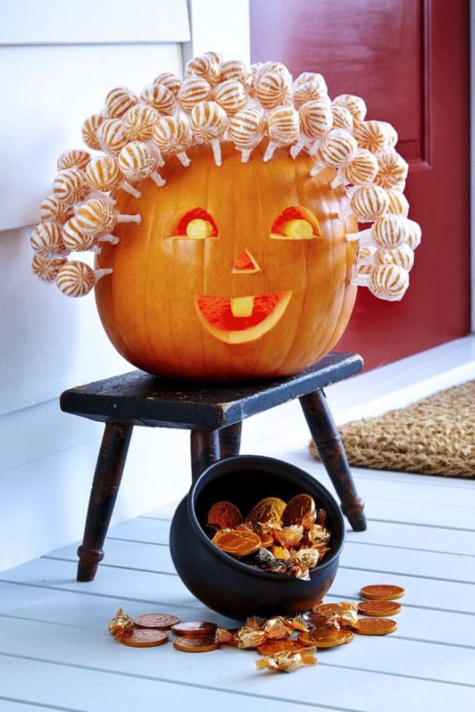 pumpkin carving idea with lollipops for hair via woman's day on the happy list