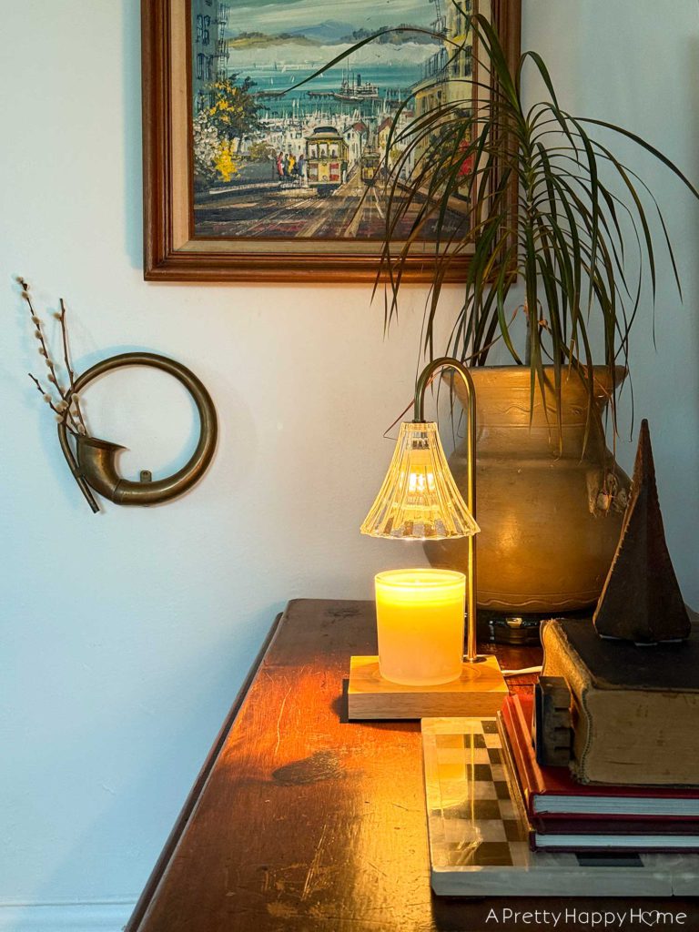 candle warmer lamps sitting on a table in front of a gallery wall 