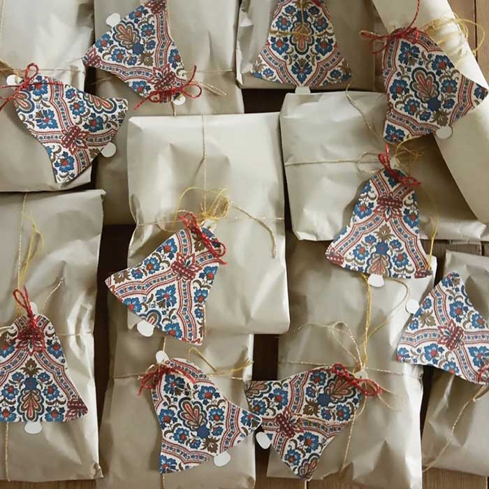 paper bells made on patterned paper and tied with string to brown paper packages at Christmas a gift wrapping idea from Ane Kirstine Bilde on the happy list