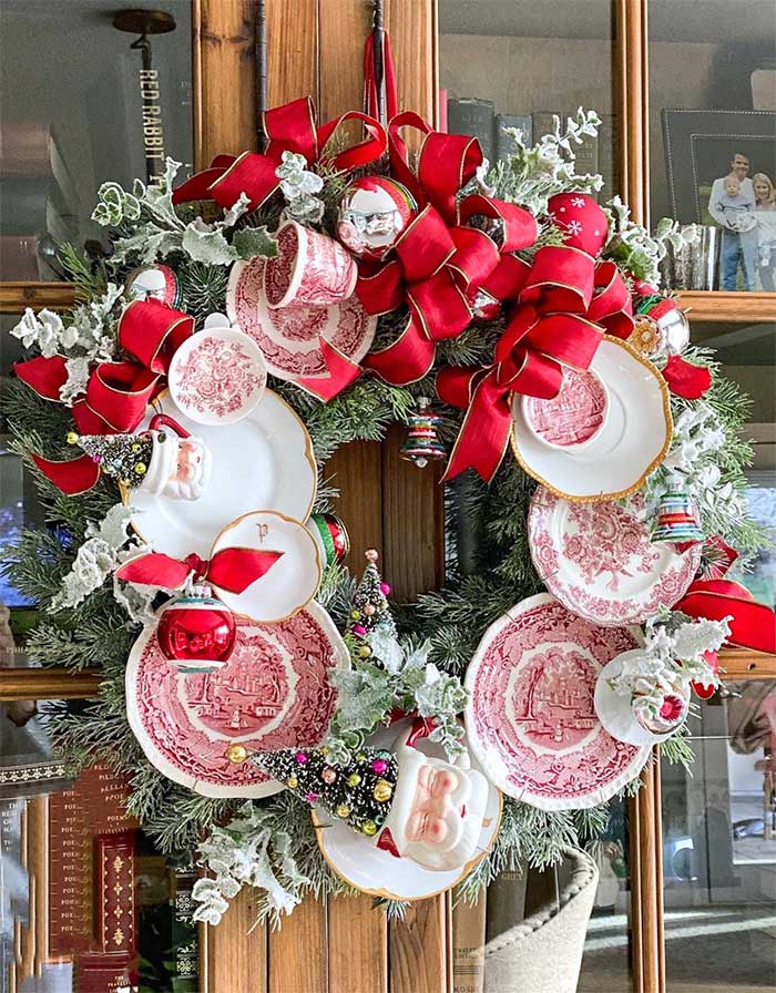christmas wreath made with red and white china plates, christmas cups, and red ribbon. The plates are attached to the wreath in a way that doesn't damage the plates. Made by Suzanne Zingg and featured on Kelly Elko's blog and on the happy list.