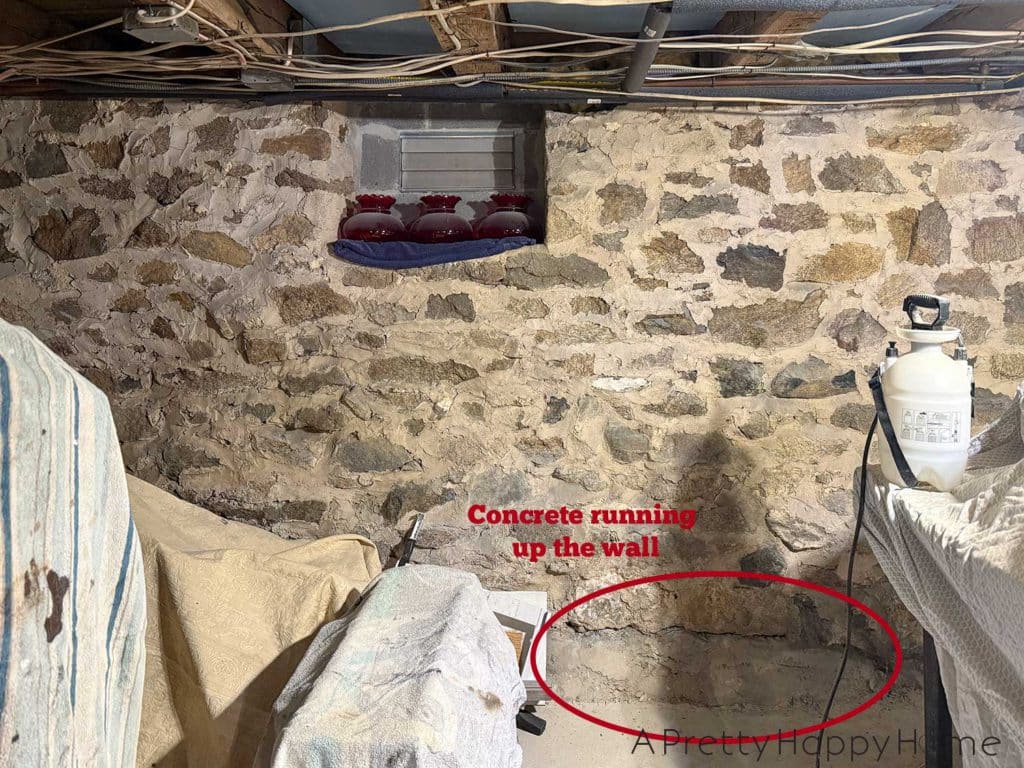 stone foundation from the 1780s chipped out to be repointed with new lime mortar. Photo shows spot at the base of the foundation wall that had been covered in concrete that was trapping moisture in the wall.