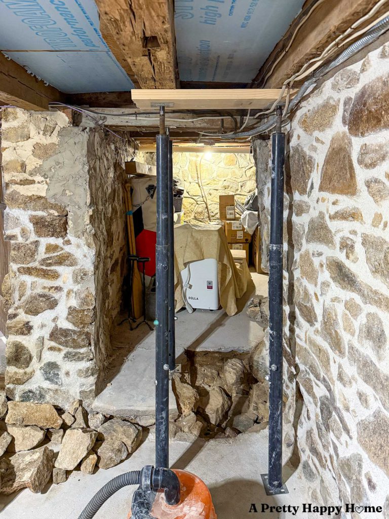 Basement of a 1780s home with a stone foundation. Part of the concrete floor was chipped up in a doorway to reveal the remains of part of the foundation wall that was taken down to create a doorway