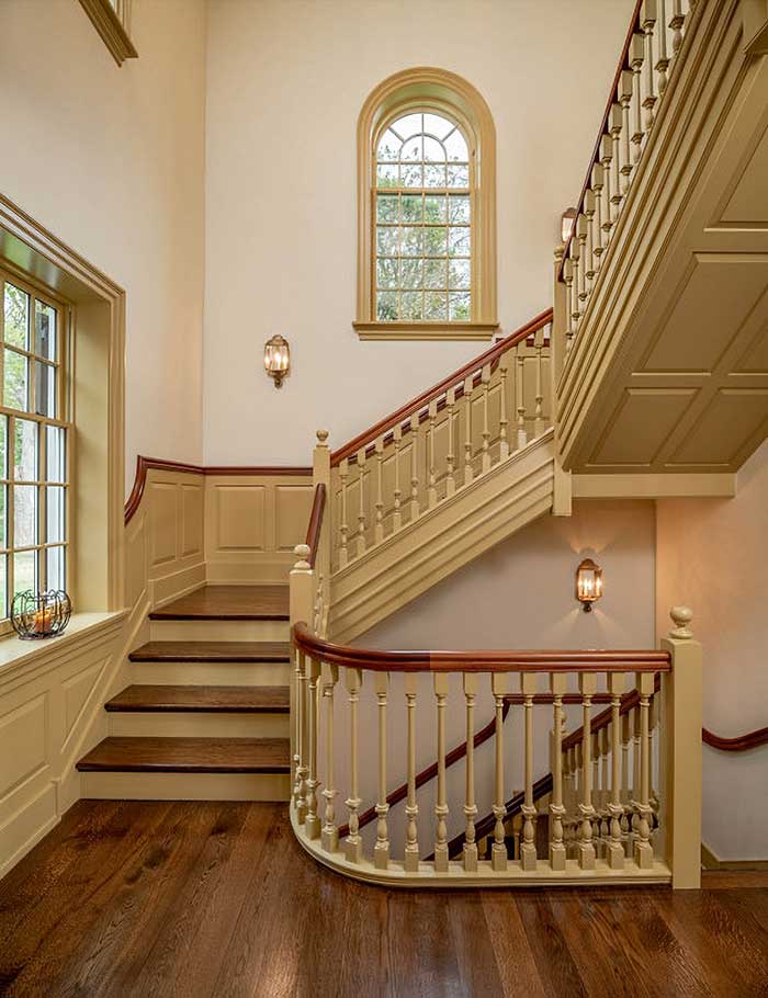 example of an ornate staircase with tan trim details that reflects period architecture